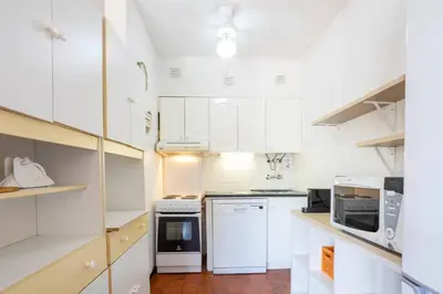 a white kitchen with white cabinets and appliances at Azure Vilamoura Apartment by HelloVacations in Loulé