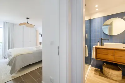 a bedroom with a bed and a sink and a mirror at Amazing Flat, 100m from beach in Quarteira