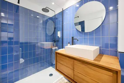 a blue tiled bathroom with a sink and a mirror at Amazing Flat, 100m from beach in Quarteira
