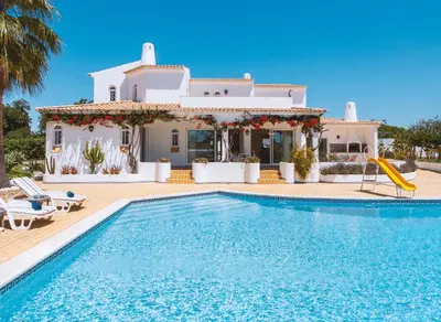 a villa with a swimming pool in front of a house at Villa Serena by Algarve Vacation in Guia