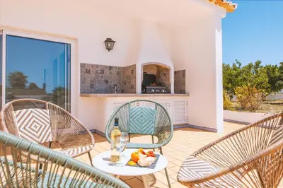 a patio with chairs and a table with food on it at Villa Serena by Algarve Vacation in Guia