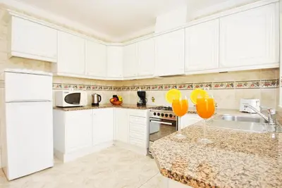 a kitchen with white cabinets and a marble counter top at Villa Puerto Rico by Algarve Vacation in Albufeira
