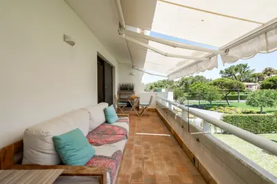 a living room with a couch on a balcony at BmyGuest Collection - Quinta do Lago Luxury Beach Apartment in Almancil