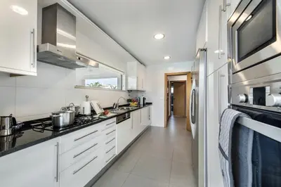 a kitchen with white cabinets and a counter top at Blue by Algarve Villa Holidays in Albufeira