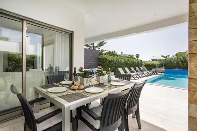 a dining room with a table and chairs and a pool at Blue by Algarve Villa Holidays in Albufeira