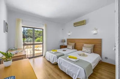 a bedroom with two beds and a large window at Villa Casa Jasmim by Villa Plus in Quarteira