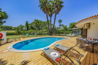 a swimming pool with chairs and a table and a patio at Villa Casa Jasmim by Villa Plus in Quarteira