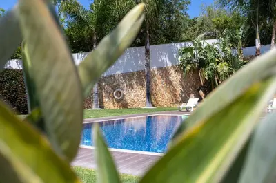 a swimming pool with a chair next to a house at Villa Monte Avós by Ecovillas Albufeira in Albufeira