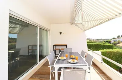 a table and chairs on the balcony of a house at Serenity 18 House by Stay ici Algarve Holiday Rental in Albufeira