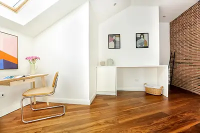 an office with a brick wall and a desk and a chair at Green Essence Duplex in Faro by Misha's Place in Faro