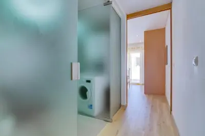 a room with a glass door with a tv in it at Side Villas - 1bdr Retreat with BBQ & Patio in Quarteira