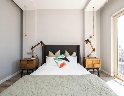 a bedroom with a large white bed with two lamps at Villa Ada in Faro