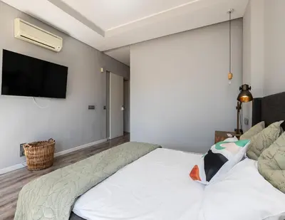 a bedroom with a bed and a tv on the wall at Villa Ada in Faro