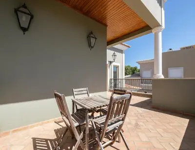 a wooden table and chairs on a patio at Villa Ada in Faro
