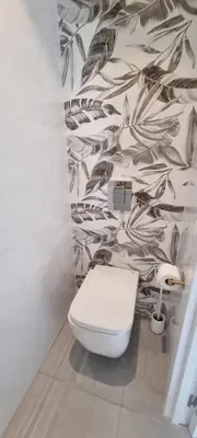 a bathroom with a toilet with a black and white wallpaper at T2 Marina Vilamoura in Quarteira