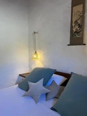 a bedroom with a bed with two blue pillows at La Casa de Casa Estréla in Loulé