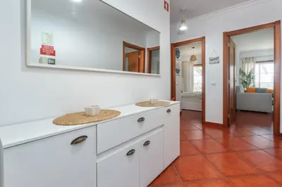a bathroom with white cabinets and a mirror on the wall at BnB Homes Apartment with cozy Terrace & 2 Swimming pools near the heart city in Albufeira