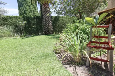 a red chair sitting in the grass in a yard at Villa Casa Pepa-Paca - Swiming Pool & Air Condition - Albufeira - Sesmarias - BY BEDZY in Albufeira