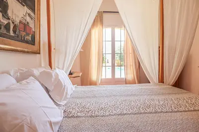 a bedroom with a white bed with a window at Villa Casa Pepa-Paca - Swiming Pool & Air Condition - Albufeira - Sesmarias - BY BEDZY in Albufeira