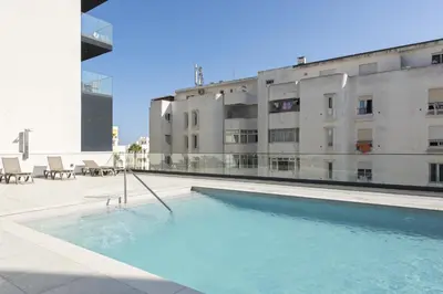 a swimming pool in front of a building at Terracos de Quarteira -Luxury Duplex Penthouse 3BR Best View, 50m from Beach in Quarteira