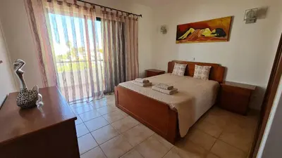 a bedroom with a bed and a desk and a window at Villa V3 - Vale Pedras in Albufeira