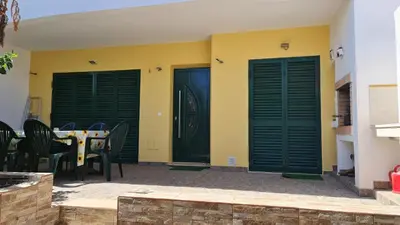 a patio with black doors and a table and chairs at Villa V3 - Vale Pedras in Albufeira