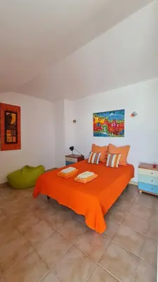 a bedroom with a bed with an orange blanket at Villa V3 - Vale Pedras in Albufeira