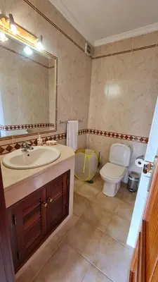 a bathroom with a sink and a toilet and a mirror at Villa V3 - Vale Pedras in Albufeira