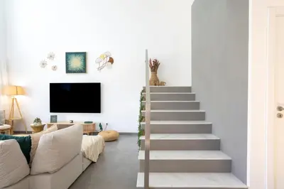 a staircase in a living room with a couch and a tv at Stylish 3-Bedroom Villa Haven with a Private Pool in Albufeira