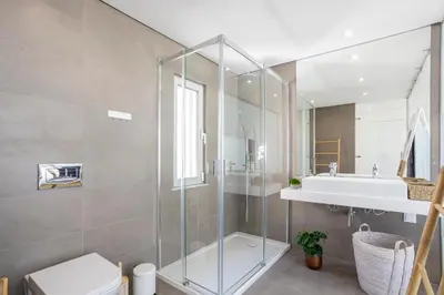 a bathroom with a glass shower and a sink at Stylish 3-Bedroom Villa Haven with a Private Pool in Albufeira