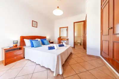 a bedroom with a large bed with blue pillows at Villa Azzurra by Algarve Vacation in Albufeira
