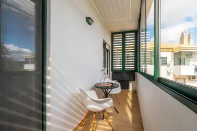 a balcony with a white chair and a table at Calm Paradise close to the City in Faro