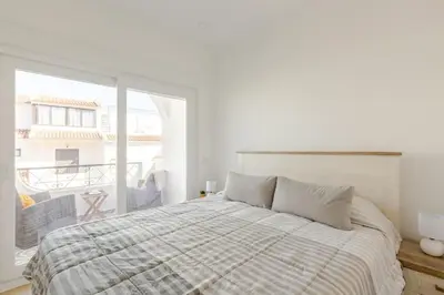 a white bedroom with a bed and a large window at BrisaMar Villas 2 Sol Mar Serenidade in Albufeira