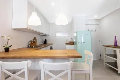 a kitchen with a blue refrigerator and white cabinets at Villa Mar e Sol by HelloVacations in Olhos de Água