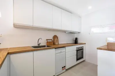 a white kitchen with white cabinets and a sink at Villa Mar e Sol by HelloVacations in Olhos de Água