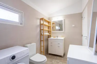 a bathroom with a toilet and a sink and a mirror at Villa Mar e Sol by HelloVacations in Olhos de Água