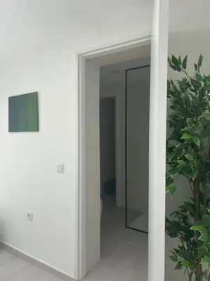 a hallway with a mirror and a plant at Casa das Mélias in Vilamoura