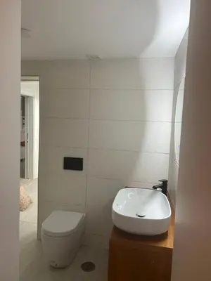 a white bathroom with a toilet and a sink at Casa das Mélias in Vilamoura