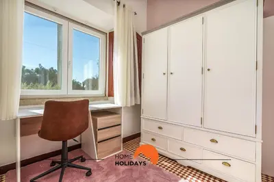 a bedroom with a desk and a chair and a window at #236 Texugueiras 148 by Home Holidays in Ferreiras