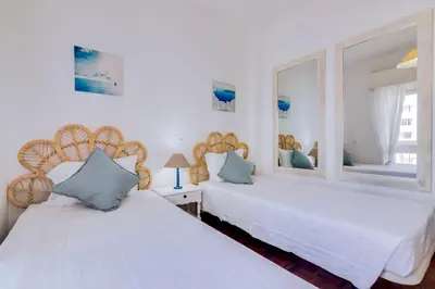 two beds in a room with white walls at Maresia 2 Bedroom Oceanfront Apartment in Quarteira in Quarteira