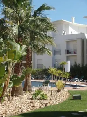 a resort with palm trees and a swimming pool at Encosta Do Sol in Albufeira