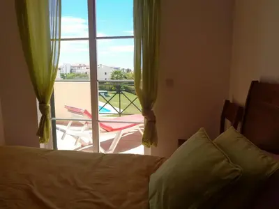 a bedroom with a bed and a view of a balcony at Apartamento Citimar in Vilamoura