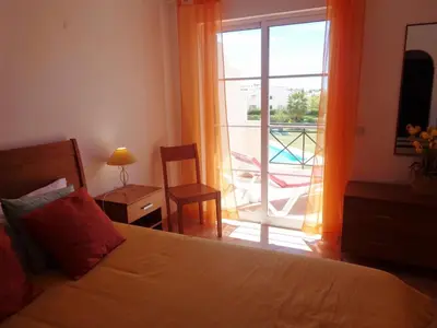 a bedroom with a bed and a view of a balcony at Apartamento Citimar in Vilamoura