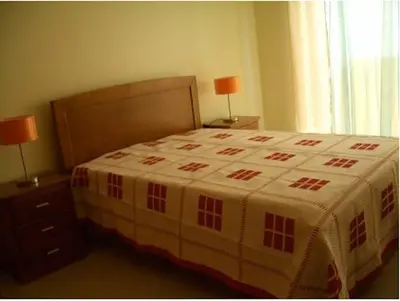 a bedroom with a bed with a blanket on it at Akisol Albufeira Aqua II in Albufeira