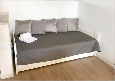 a bed in a small room with a gray mattress at Windmill Hill - Alto do Moinho - Pool & Sea View in Albufeira
