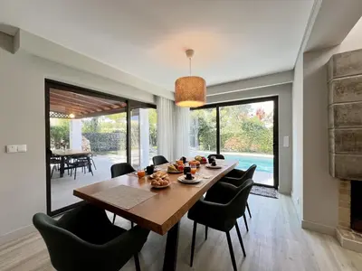 a dining room with a wooden table and chairs at Vilamoura Premium Villa With Pool by Homing in Vilamoura
