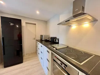a kitchen with a stove top oven next to a refrigerator at Vilamoura Premium Villa With Pool by Homing in Vilamoura