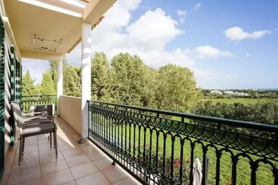 a balcony with a view of a field and trees at Villa Nascente Balaia in Branqueira
