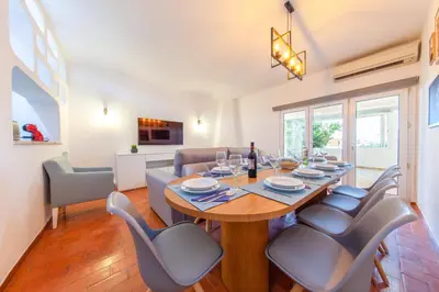 a dining room and living room with a table and chairs at Villa Palancar by Algarve Vacation in Albufeira