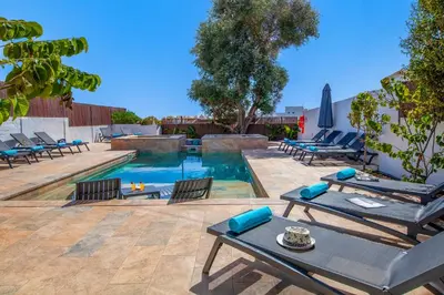 a swimming pool with lounge chairs and a table at Villa Palancar by Algarve Vacation in Albufeira
